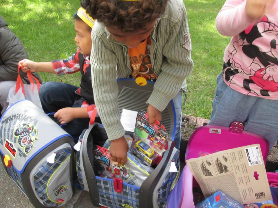 Vier Kinder, die gerade in ihren neuen Schulranzen die Geschenke bestaunen.